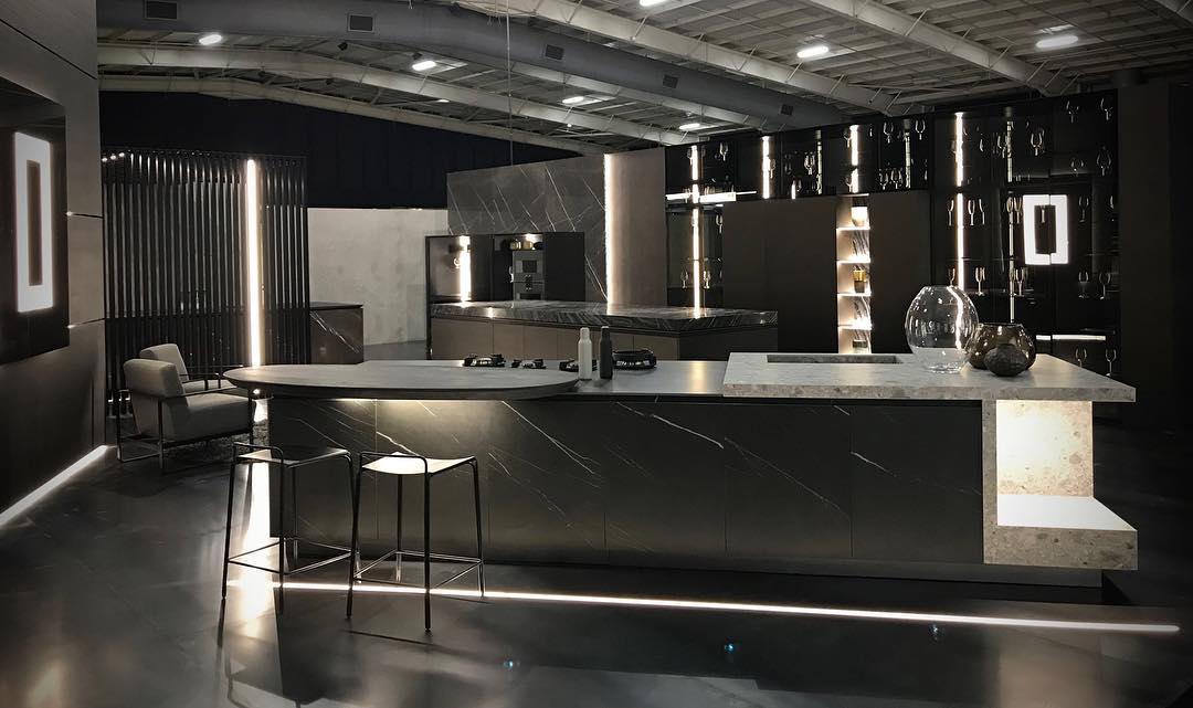 Showroom kitchen featuring marble-veined stone worktops and a feature island